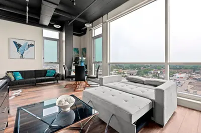 a living room with a couch and a large window at Finch West Residence Suites - Hotel DUKE in Toronto