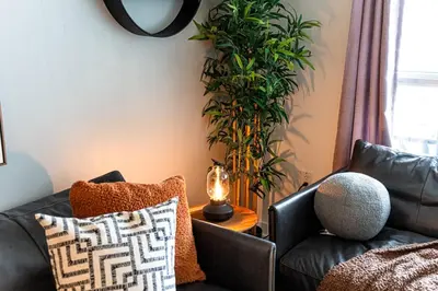 a living room with a couch and a plant at The Hideaway Hub in Toronto