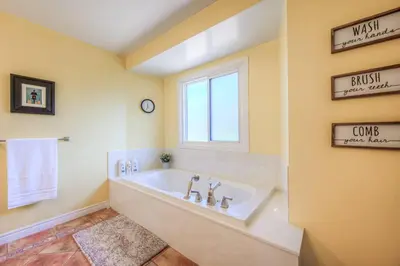 a large bathroom with a tub and a window at 45 per Off Monthly Stay - 7 Beds - BBQ in Kitchener