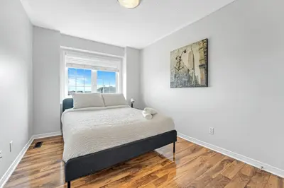 a white bedroom with a bed and a window at Elegant 3Bedroom with Smart TV and Backyard in Mississauga