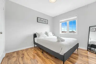 a white bedroom with a bed and a window at Elegant 3Bedroom with Smart TV and Backyard in Mississauga