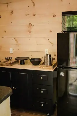 a kitchen with a counter and a black refrigerator at The Green Acres Cabin in Hamilton