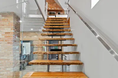 a staircase with wooden treads and a brick wall at ENTIRE BACHELOR UNIT EN-SUITE ACROSS FROM GOOGLE - br4 in Kitchener