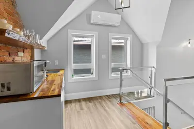 a kitchen with a staircase and two windows at ENTIRE BACHELOR UNIT EN-SUITE ACROSS FROM GOOGLE - br4 in Kitchener