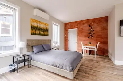a bedroom with a bed and a table and a chair at ENTIRE BACHELOR UNIT EN-SUITE ACROSS FROM GOOGLE - br3 in Kitchener