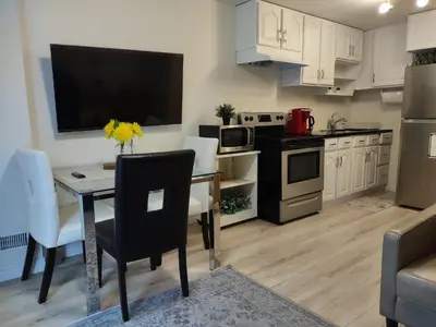 a kitchen with a dining table with a television on the wall at Basement Waterloo Near 24-7 Restraints in Waterloo