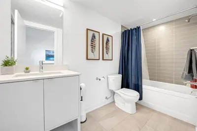 a bathroom with a toilet and a sink and a tub at Posh 4 Bed Home with Backyard in Great Location in Burlington