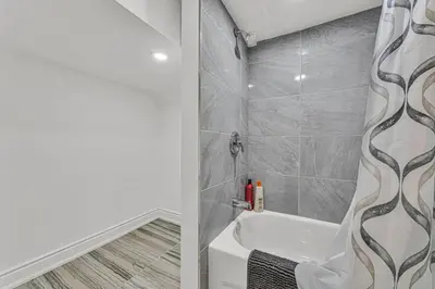 a bathroom with a shower and a white tub at Luxury Comfort 3 BR Near Hospitals Tims Field GO in Hamilton