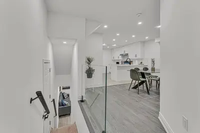 a white kitchen and dining room with a table and chairs at Luxury Comfort 3 BR Near Hospitals Tims Field GO in Hamilton