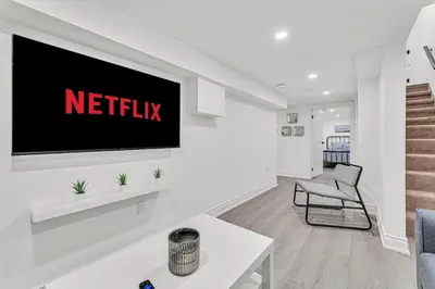 a living room with a television on a wall at Luxury Comfort 3 BR Near Hospitals Tims Field GO in Hamilton