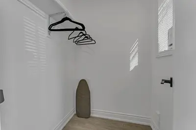 a white room with hangers hanging on a wall at Luxury Comfort 3 BR Near Hospitals Tims Field GO in Hamilton