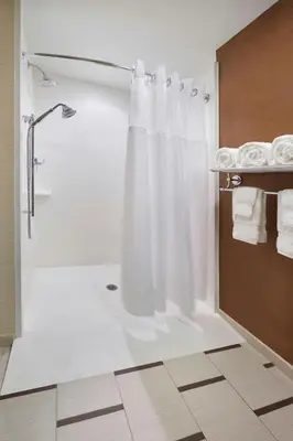 a bathroom with a shower with a white shower curtain at Fairfield Inn & Suites by Marriott Barrie in Barrie