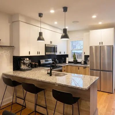 a kitchen with a island with a sink and a refrigerator at Beautiful modern 2Bdr sunny home with French decor in Hamilton