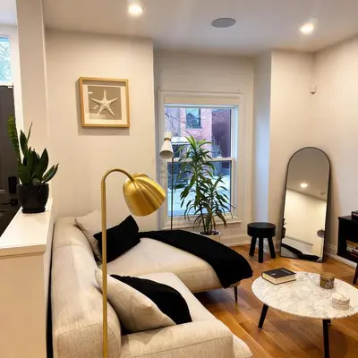 a living room with a bed and a table at Beautiful modern 2Bdr sunny home with French decor in Hamilton