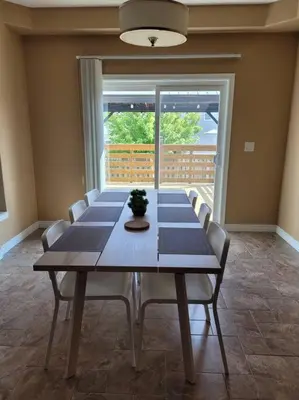 a dining room with a long table and chairs at Huge Family home sleeps 10 with 3 parking spots in Kitchener