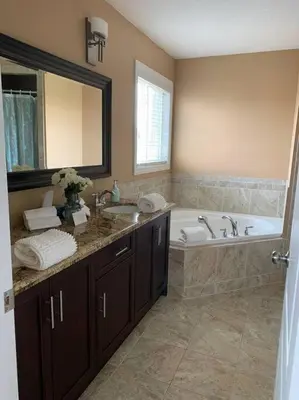 a bathroom with a tub and a sink and a bath tub at Huge Family home sleeps 10 with 3 parking spots in Kitchener
