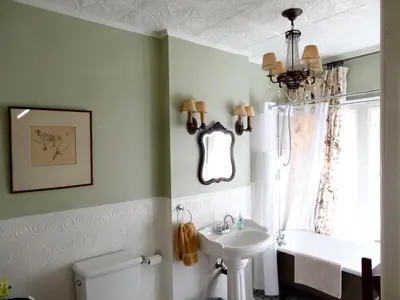 a bathroom with a sink and a toilet and a window at The Captain's House heritage bed & breakfast in Midland