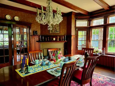 a dining room with a table and chairs and a chandelier at The Captain's House heritage bed & breakfast in Midland
