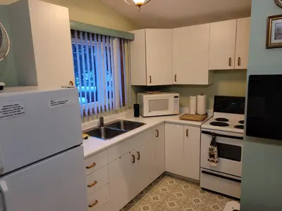 a small kitchen with white appliances and a window at Bowering Lodge in Blue Mountains