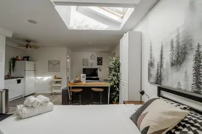 a bedroom with a white bed and a kitchen at West House Private Garden Suite with Skylight in Brampton