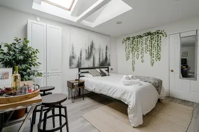 a bedroom with a bed and a table with chairs at West House Private Garden Suite with Skylight in Brampton