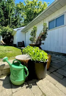 a patio with a table and some plants and a vase at West House Private Garden Suite with Skylight in Brampton