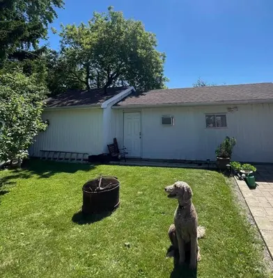 a dog sitting in the yard of a house at West House Private Garden Suite with Skylight in Brampton