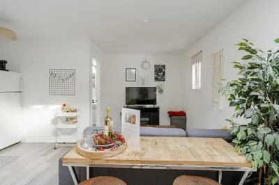 a living room with a table and a couch at West House Private Garden Suite with Skylight in Brampton