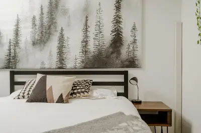 a bedroom with a bed with a picture of trees at West House Private Garden Suite with Skylight in Brampton