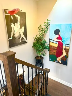 a staircase with two paintings of a woman with an umbrella at Central Toronto in Toronto