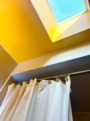 a bathroom with a white shower curtain and a skylight at Central Toronto in Toronto