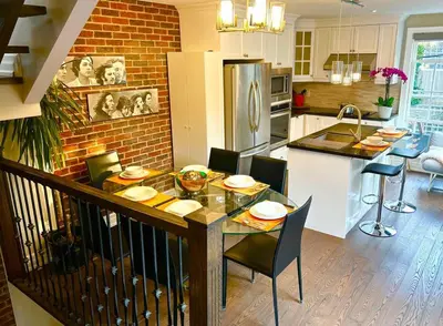 a kitchen with a dining table with chairs and a kitchen with a counter at Central Toronto in Toronto