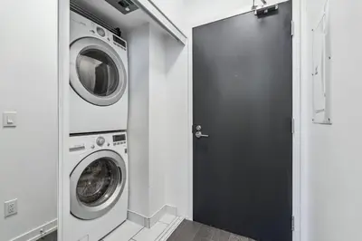a laundry room with a washing machine and a door at Amazing View 2BR St Lawrence Market Condo, Downtown Toronto in Toronto