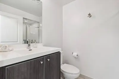 a white bathroom with a toilet and a sink at Amazing View 2BR St Lawrence Market Condo, Downtown Toronto in Toronto