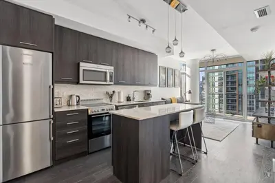 a kitchen with a stainless steel refrigerator and cabinets at Amazing View 2BR St Lawrence Market Condo, Downtown Toronto in Toronto