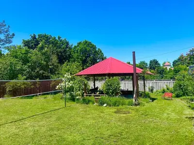 a gazebo with a red roof in a yard at Moon River in Campbellford