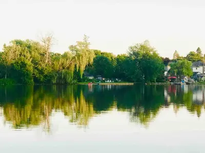 a large body of water with trees and houses at Moon River in Campbellford