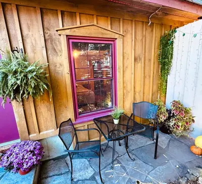 a patio with chairs and a table and a window at The Cozy Corner in Elora