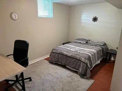 a bedroom with a bed and a desk and a chair at Cozy 2BR Basement Near Two Lakes in Richmond Hill