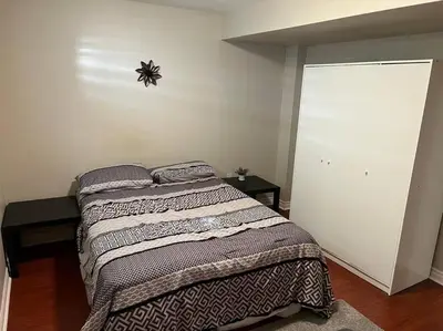 a bedroom with a bed and a wall at Cozy 2BR Basement Near Two Lakes in Richmond Hill