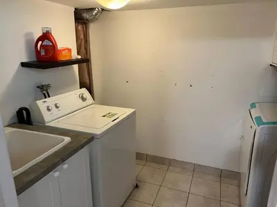 a small kitchen with a sink and a washing machine at Cozy 2BR Basement Near Two Lakes in Richmond Hill