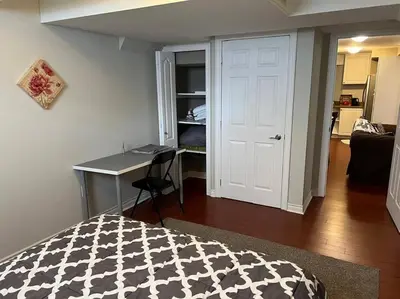 a bedroom with a bed and a desk with a table at Cozy 2BR Basement Near Two Lakes in Richmond Hill