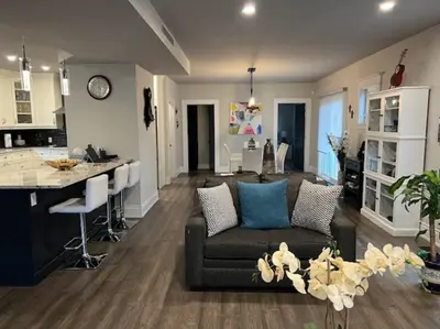 a living room with a couch and a kitchen at Luxury and comfy Home- Niagara getaway in Niagara Falls