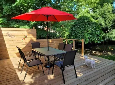 a table and chairs with a red umbrella on a deck at Luxury and comfy Home- Niagara getaway in Niagara Falls