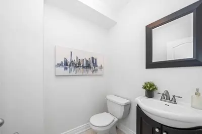 a bathroom with a toilet and a sink and a mirror at Charming Family Getaway in Richmond Hill in Richmond Hill
