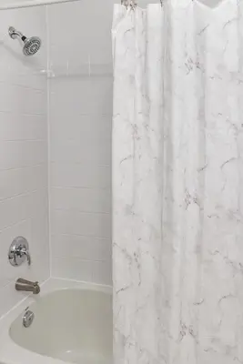 a white shower curtain in a bathroom with a tub at City View Towers - Steps to CN Tower - Indoor Pool - Save on 4 weeks stay in February in Toronto