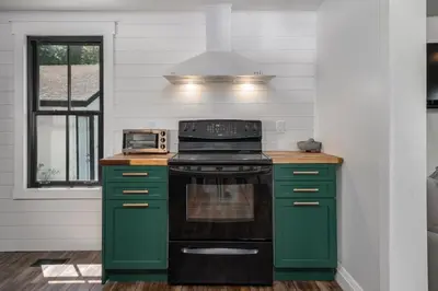 a kitchen with green cabinets and a stove at Carson's Creek in Hillier