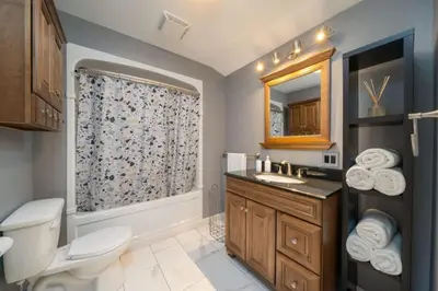 a bathroom with a toilet and a sink and a mirror at Carson's Creek in Hillier
