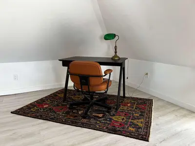 a desk with a chair and a lamp on a rug at Carson's Creek in Hillier