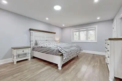 a white bedroom with a bed and a window at Newly renovated luxury villa in Stouffville, ON in Stouffville